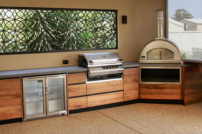 outdoor kitchen design with BBQ and bar fridge and pizza oven